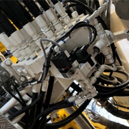 Bloc hydraulique industriel avec flexibles et connectiques lors d’une opération de maintenance.